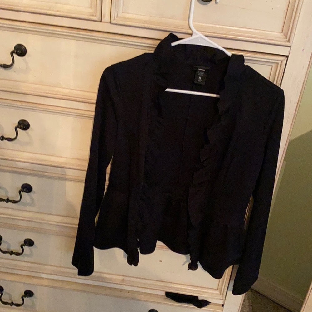 Black dress jacket with ruffle around neck  and collar ruffle flared back